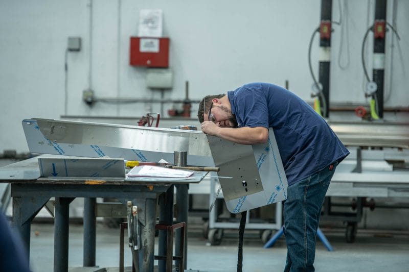 Fabricator fitting and aligning stainless panel assembly prior to welding.